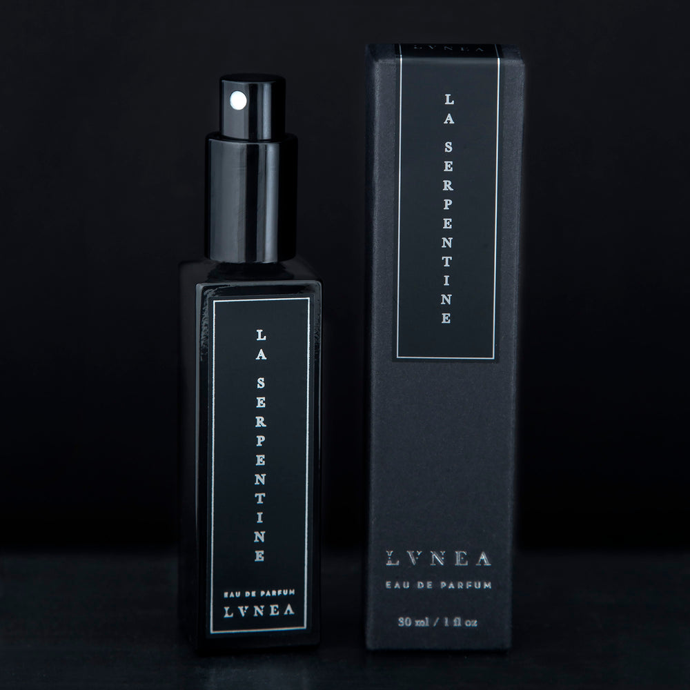 
                      
                        30ml black glass bottle of La Serpentine natural perfume sitting next to the black box it comes packaged in
                      
                    
