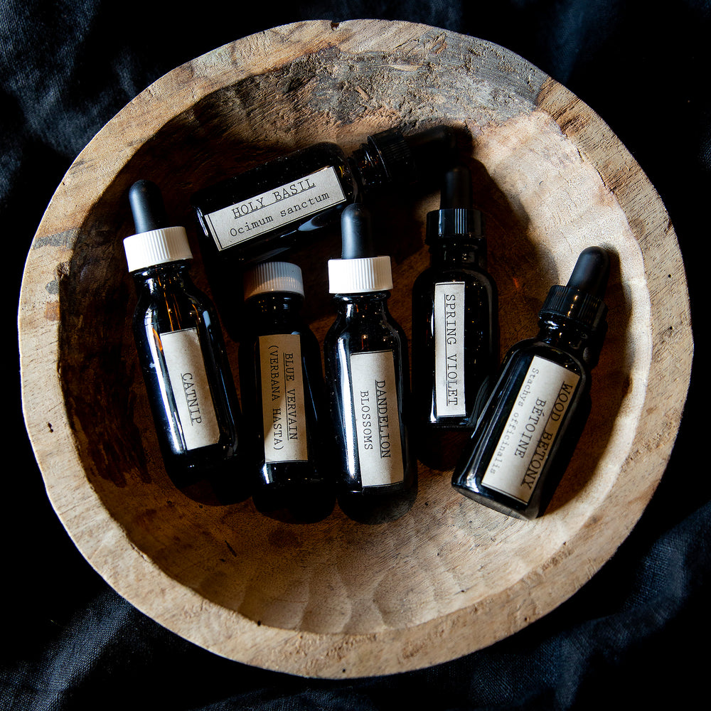Wooden bowl filled with 6 assorted bottles of blueberryjams' single origin herbal tinctures.