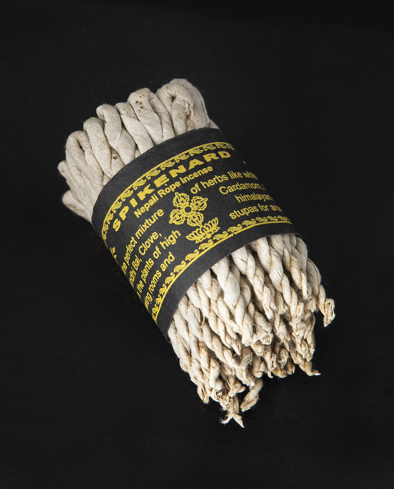 Bundle of spikenard rope incense wrapped together with black paper label.