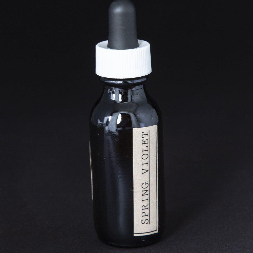 black glass bottle with dropper top of blueberryjams' spring violet herbal tincture.