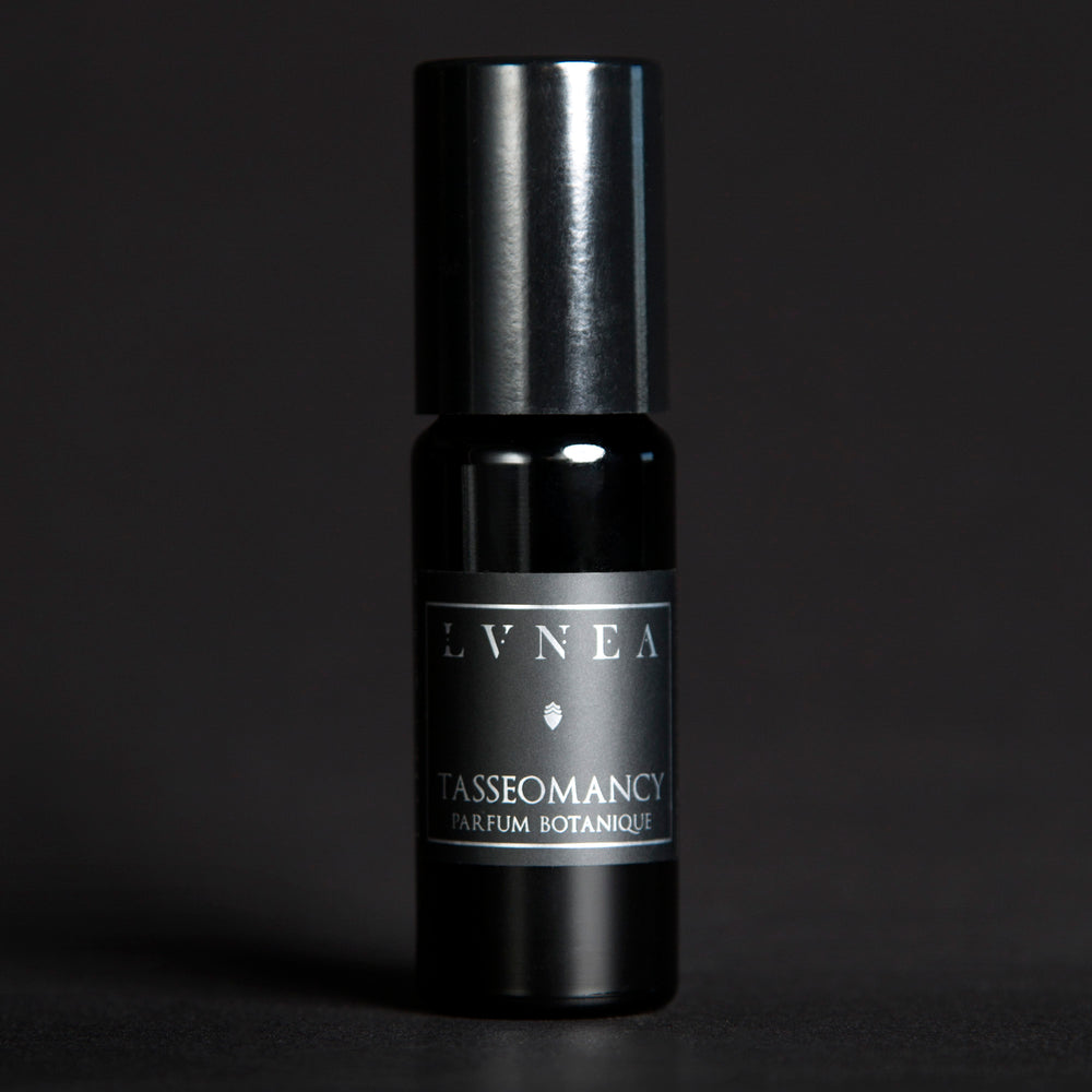 10ml black glass bottle of LVNEA's Tasseomancy natural roll on perfume oil on black background