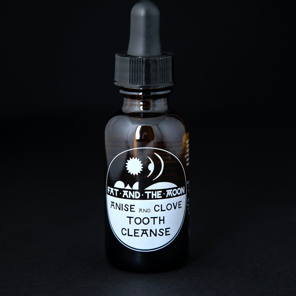1oz amber glass bottle with black dropper top containing Fat and the Moon's "Anise and Clove Tooth Cleanse".