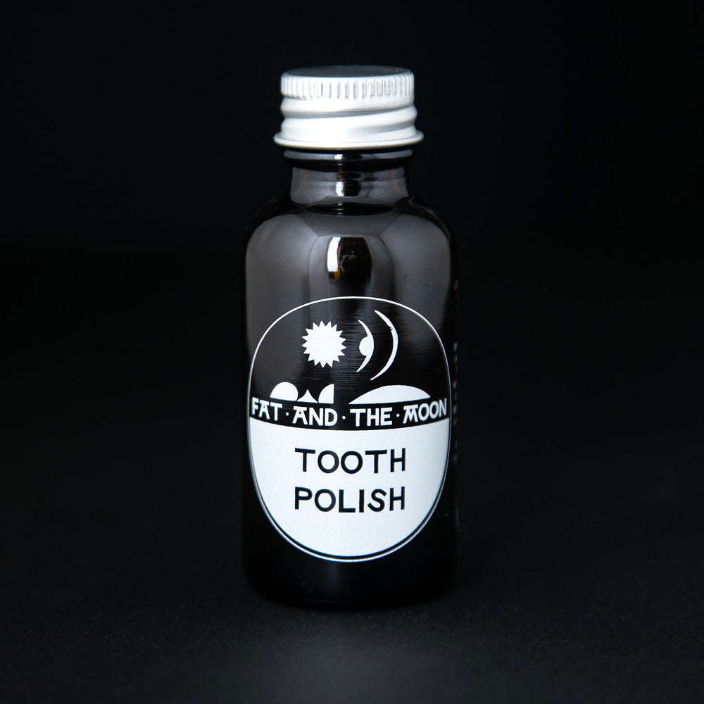 Amber glass bottle with metal screw on lid containing Fat and the Moon's "Tooth Polish".