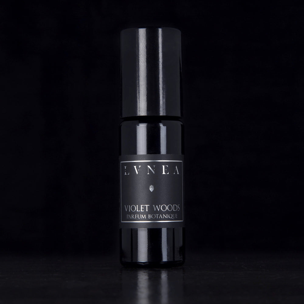 10ml black glass bottle of LVNEA's Violet Woods natural roll on perfume oil on black background