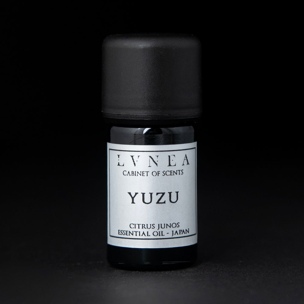 5ml black glass bottle of LVNEA's yuzu essential oil on black background. The label on the bottle is silver.